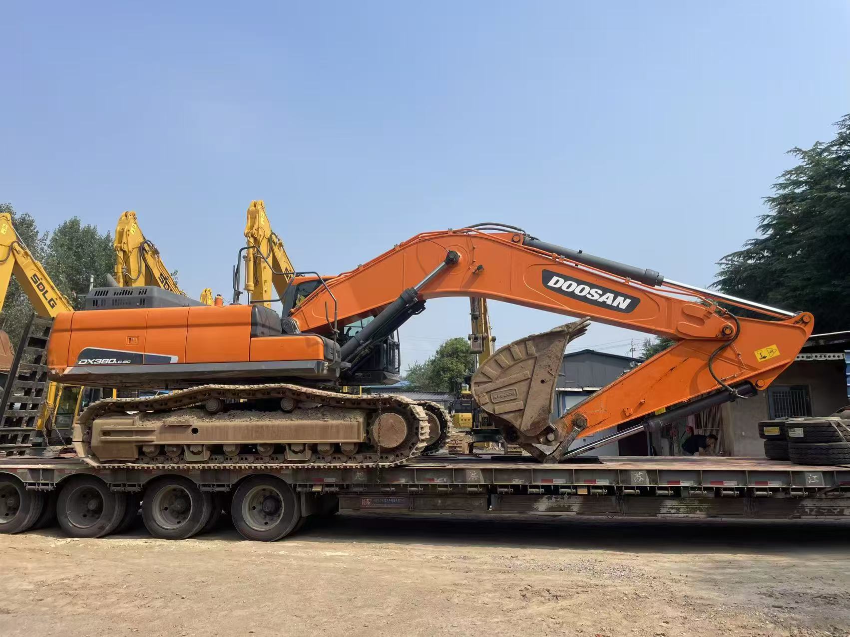 Large Doosan crawler excavator positioned on a multi-axle low-bed trailer.