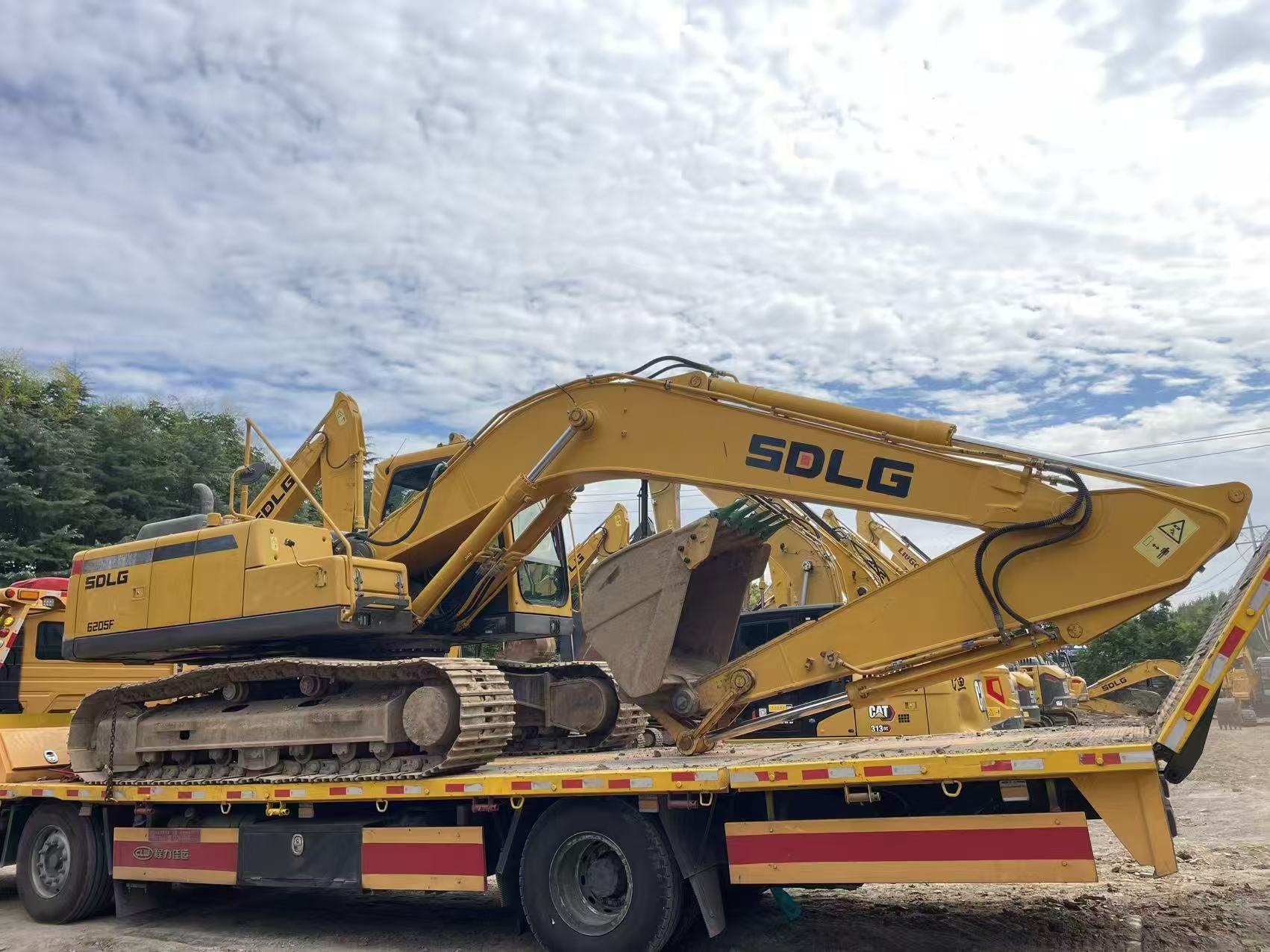 SDLG crawler excavator secured on a low-bed trailer for dispatch from the yard.